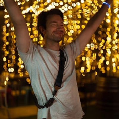 a man standing in front of a christmas tree