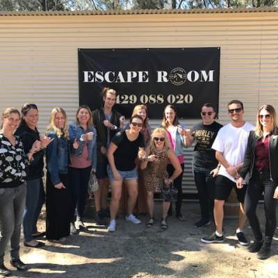 a group of people standing in front of a sign posing for the camera