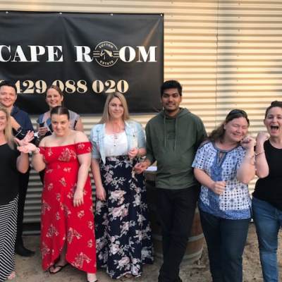 a woman standing in front of a group of people posing for the camera