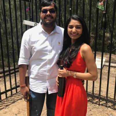 a man and a woman standing next to a fence