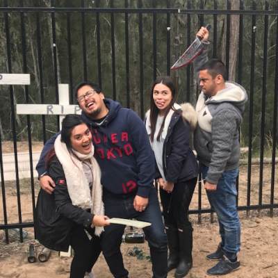 a group of people standing in front of a fence